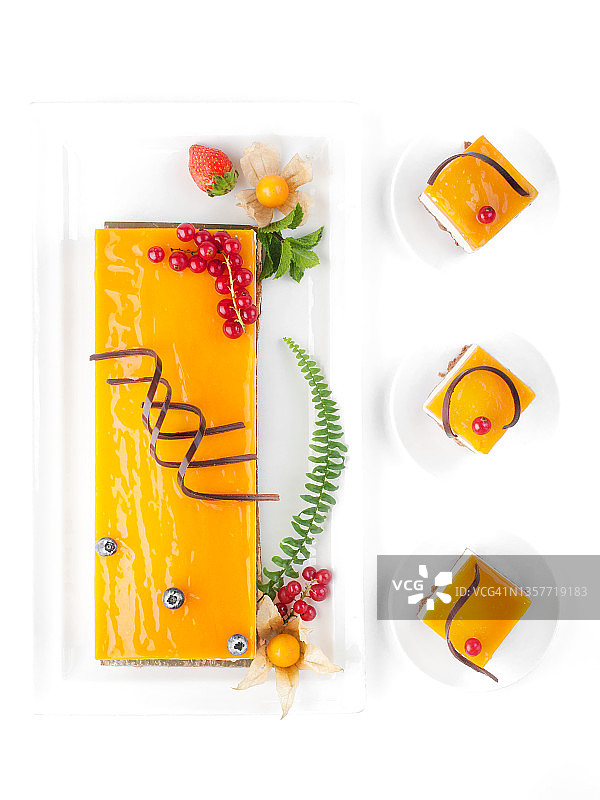 自制慕斯蛋糕俯视图美食摄影，海绵蛋糕、奶油舒芙蕾，橙子酱和透明明胶釉料，白色背景特写图片素材