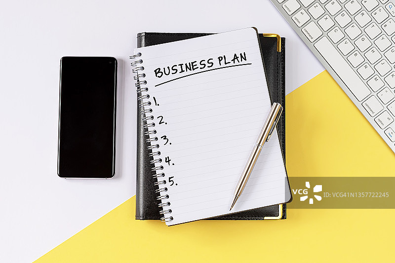 智能手机与记事本上的商业计划图片素材