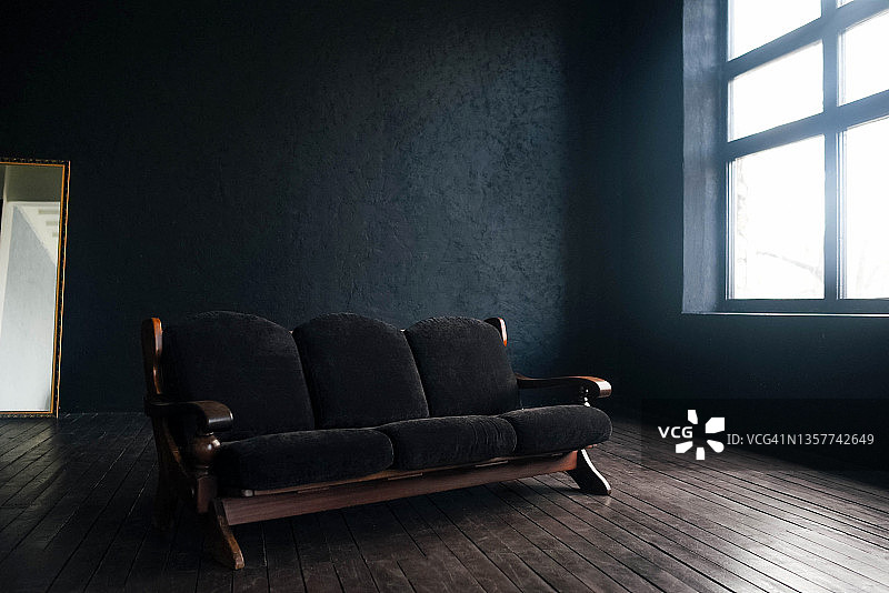 深色背景上的大型深色沙发图片素材