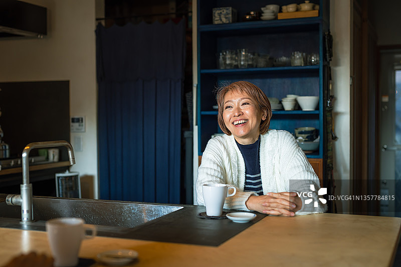 邀请朋友到家里在客厅喝咖啡的女人图片素材