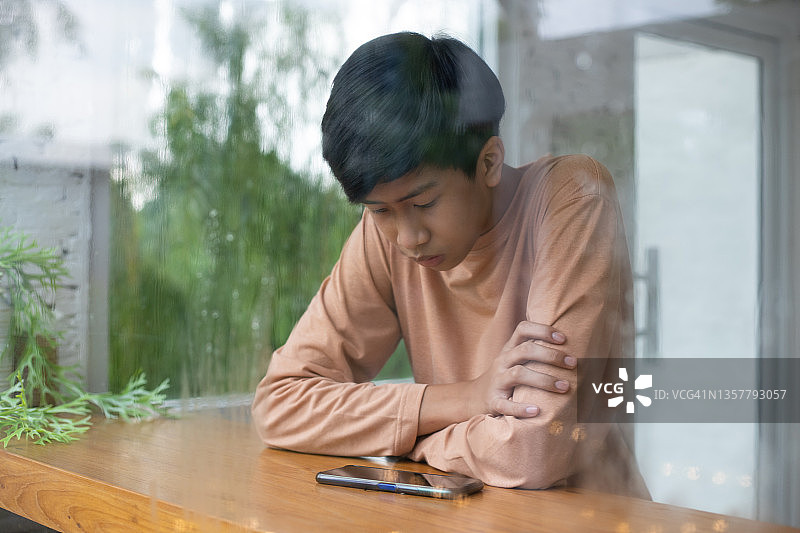 使用智能手机的亚洲男学生图片素材