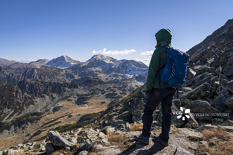 登山者：年轻女子沿着高山徒步小径前进图片素材