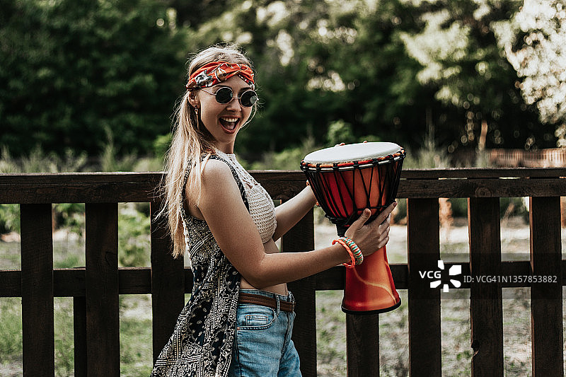 抱着非洲鼓的年轻嬉皮女子图片素材