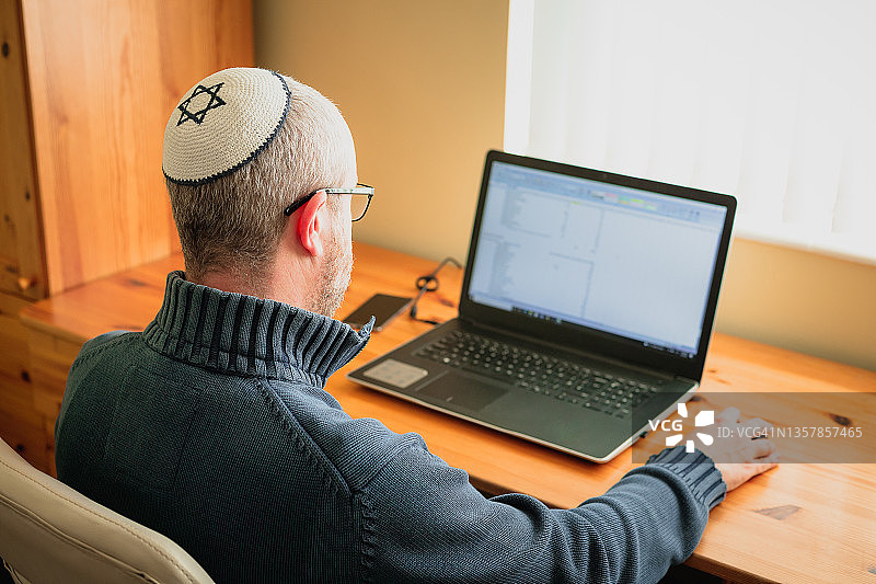 戴小帽的犹太男人在家工作图片素材