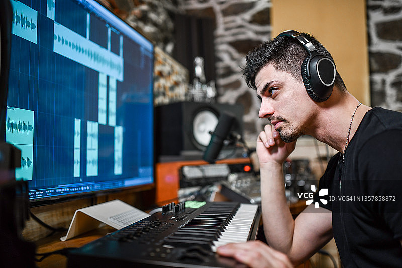 制作人在MIDI键盘上编程节拍前听歌图片素材