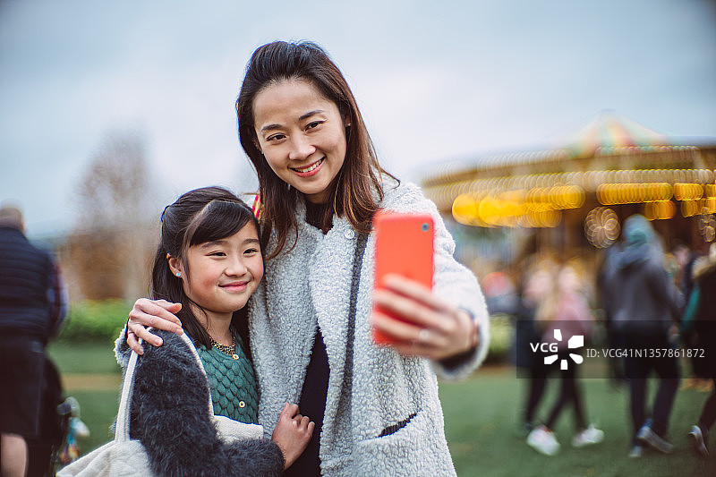 妈妈和女儿在游乐场高兴地自拍图片素材