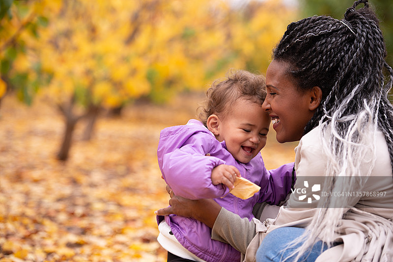 快乐的母亲和孩子在秋天的户外图片素材