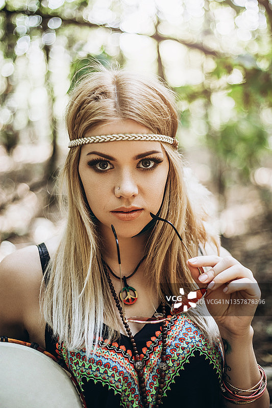 在森林里敲非洲鼓的年轻嬉皮士女性图片素材