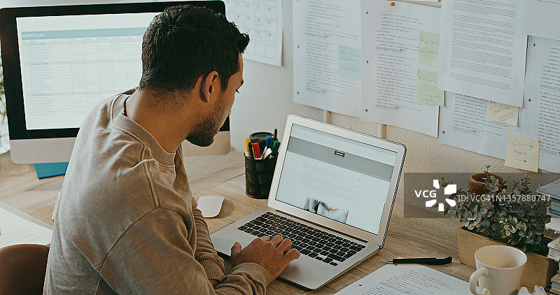 一位身份不明的商人在家工作时使用笔记本电脑的照片图片素材