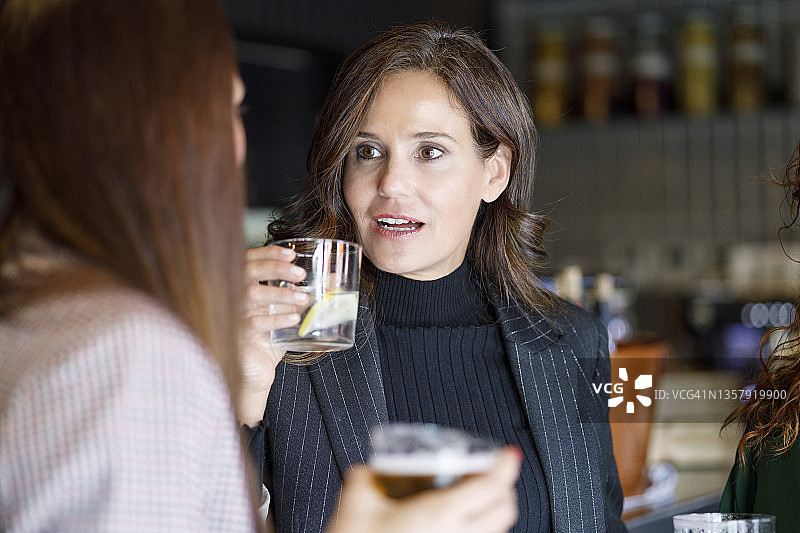 女商人在酒吧与同事讨论图片素材