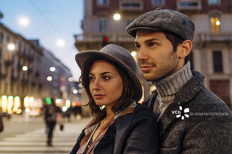 戴帽子的自信的年轻夫妇在城市里眺望远方图片素材