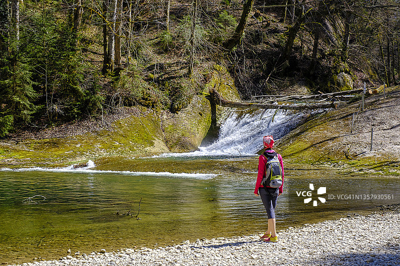 背包客站在德国巴伐利亚施瓦本的奥伯阿尔根河畔图片素材