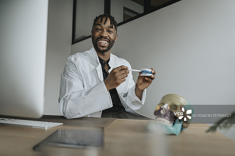 牙医在办公室用数字化笔指向假牙图片素材