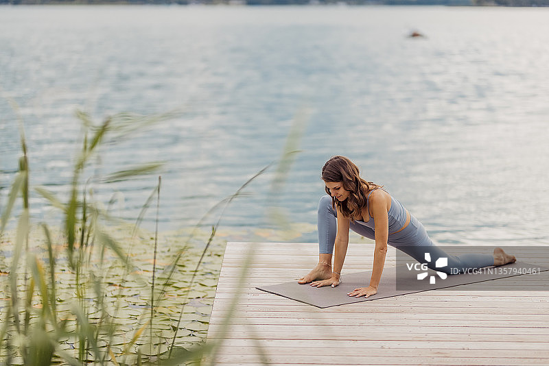 在码头上练习瑜伽的活力女人图片素材