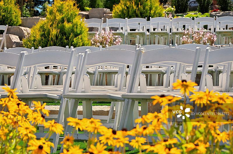 户外花园中排列的白色婚礼椅图片素材
