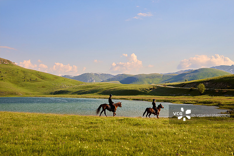 游客夫妇在湖边享受骑马的乐趣图片素材