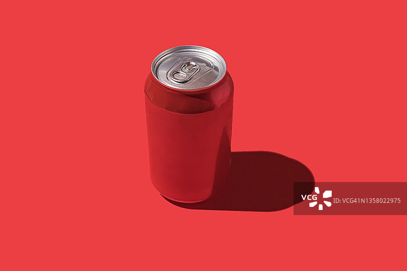 红色苏打水罐，红色背景上的硬阴影图片素材