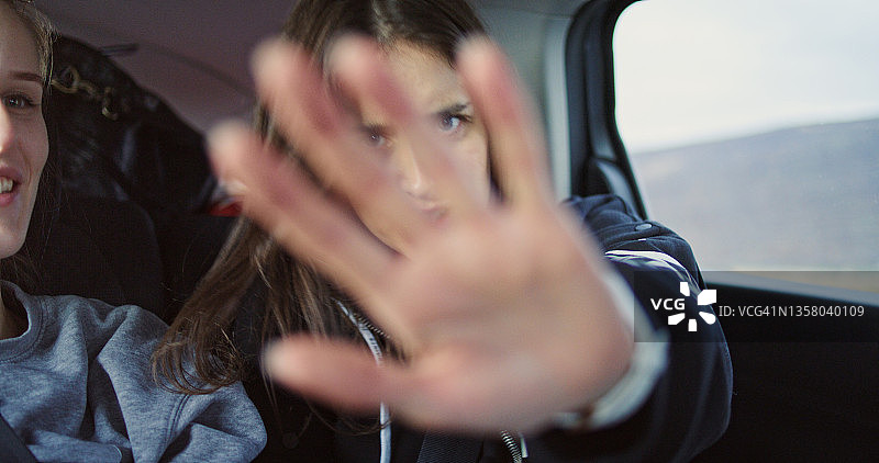 请勿拍照！年轻女人车内遮挡相机镜头图片素材