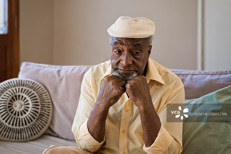 客厅里手托下巴的老年男人图片素材