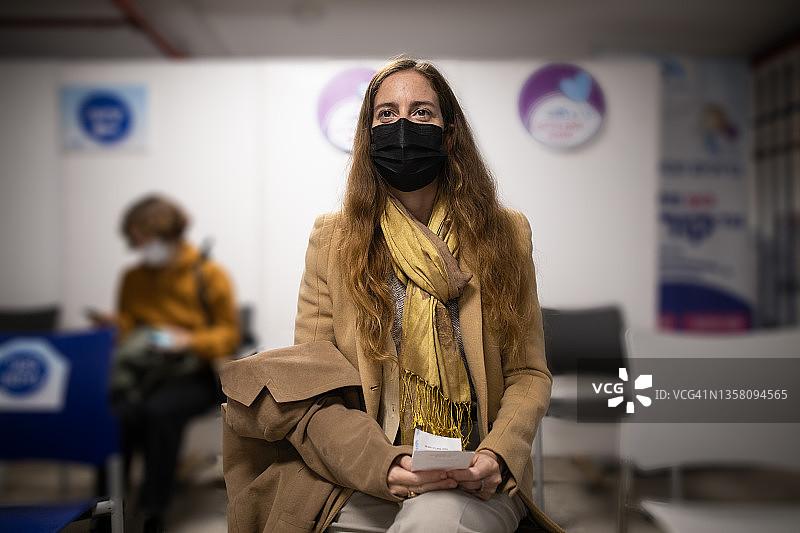 在疫苗接种中心候诊区等待的女人图片素材