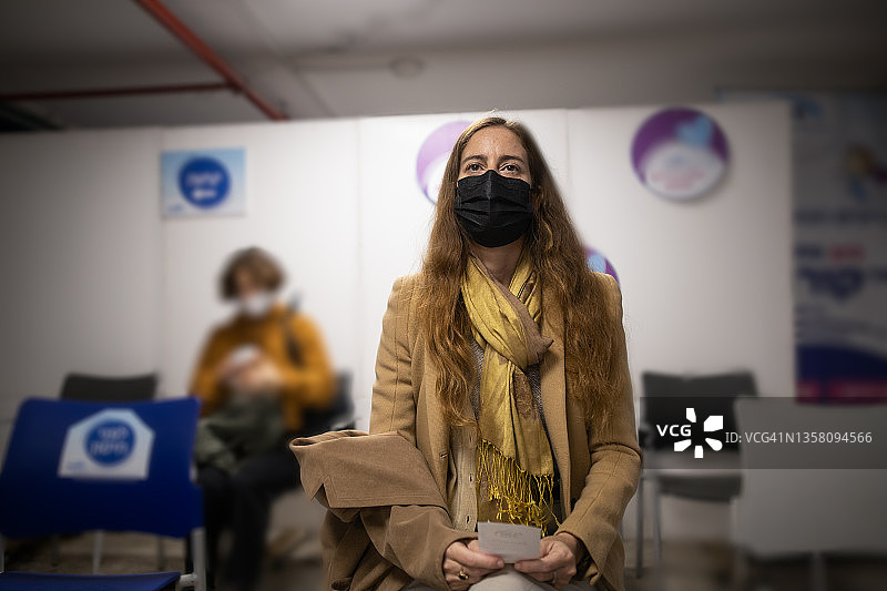 在疫苗接种中心候诊区等待的女人图片素材