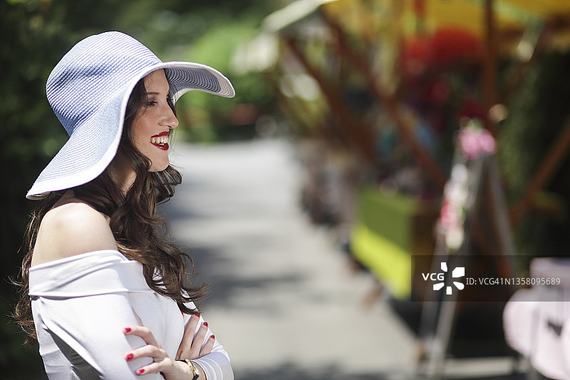 身穿白色衣服的年轻女子在街头集市图片素材