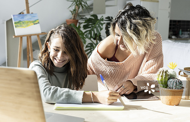 母亲和女儿在家做作业图片素材