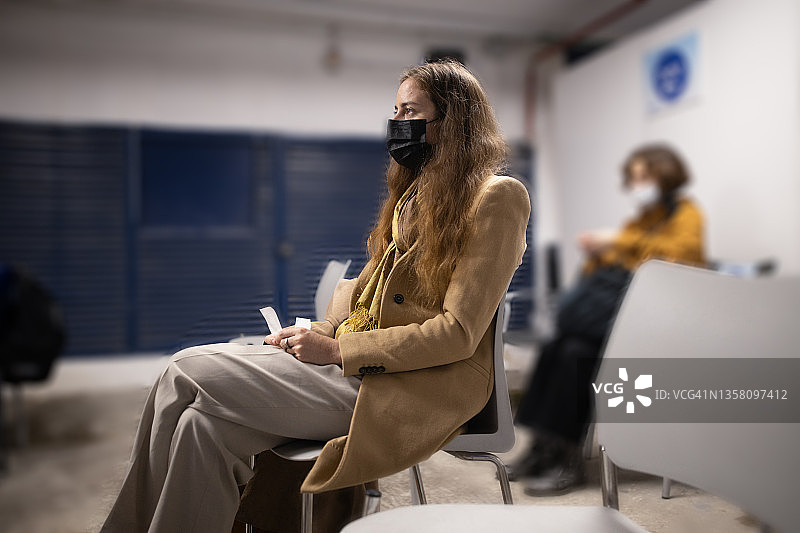 在疫苗接种中心候诊区等待的女人图片素材