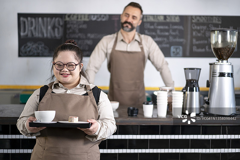 在咖啡馆工作的唐氏综合征年轻女性图片素材