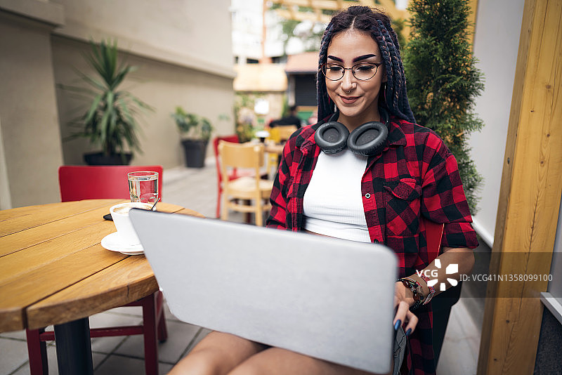 从咖啡店里，年轻的女自由职业者态度很酷地用笔记本电脑进行视频通话图片素材