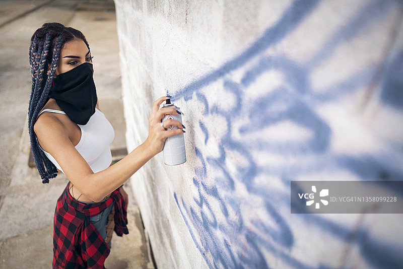 在废弃工业建筑墙壁上涂鸦的白人女子图片素材