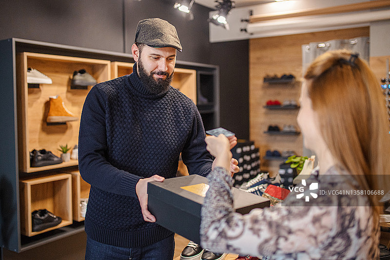男子在鞋店购买鞋子图片素材