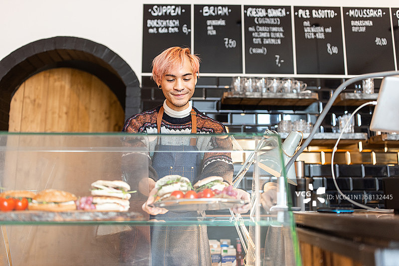 咖啡师在咖啡馆展示柜台摆放食物图片素材