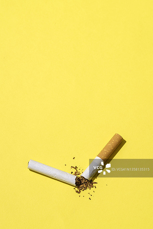 黄色背景上的断裂香烟，新年决心图片素材