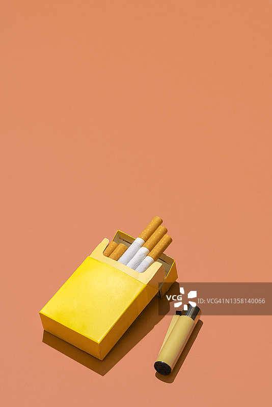 珊瑚色背景上的黄色香烟盒图片素材