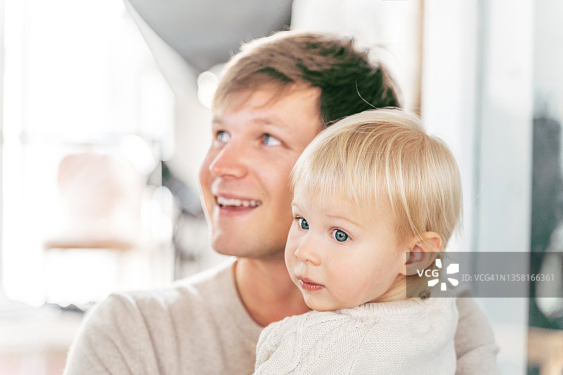 快乐的欧洲英俊父亲拥抱他可爱的小宝宝，幸福地微笑图片素材