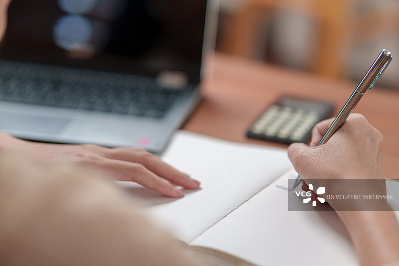 女学生在笔记本上写字特写图片素材