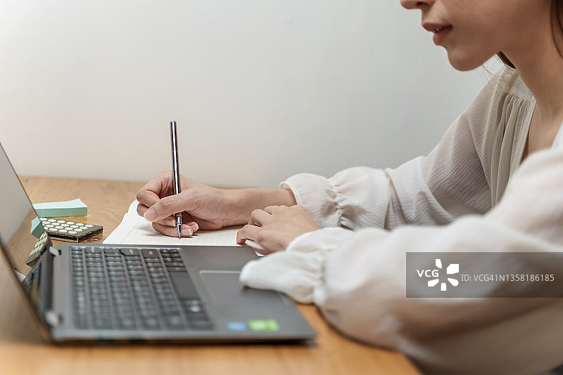 女学生在笔记本上写字特写图片素材