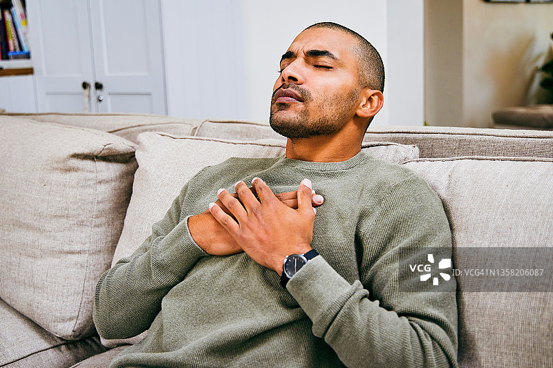 在家中感到胸痛的年轻人图片素材