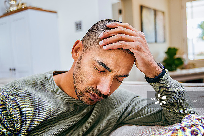 在家放松时头痛的年轻男人照片图片素材