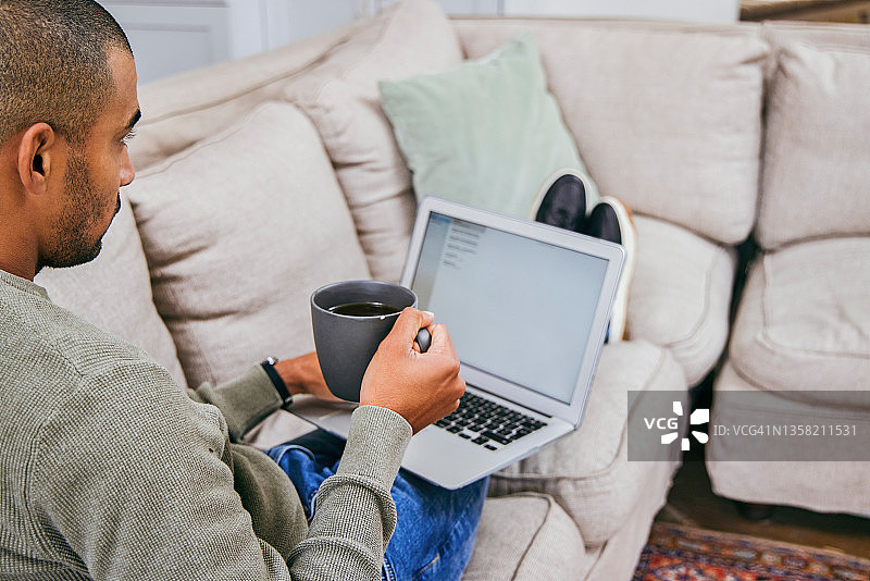 男人在家用笔记本电脑喝咖啡图片素材