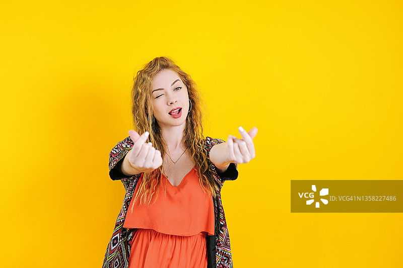 吐舌头的年轻女子（橙色连衣裙）图片素材