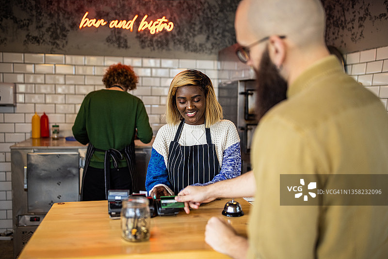 在快餐店使用非接触式支付进行购买的白人顾客图片素材