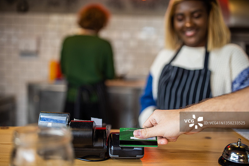 快餐店里用信用卡付款的顾客图片素材
