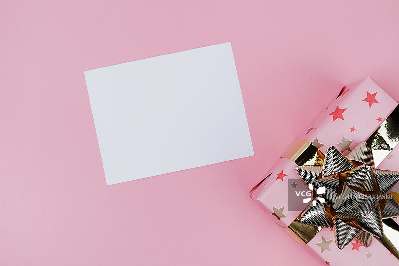 星星装饰的粉色礼品盒与金色蝴蝶结图片素材