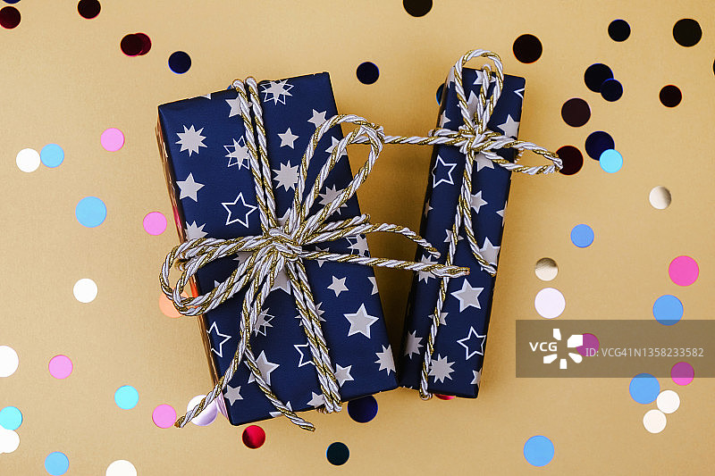 用金色和银色蝴蝶结装饰的蓝色礼品盒图片素材