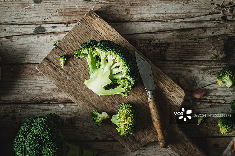 刀和切好的新鲜西兰花在木制砧板上图片素材