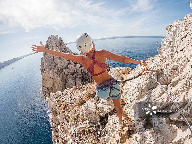 攀岩者在铁索栈道上欣赏海景图片素材