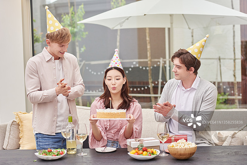 一个女人和两个男人参加生日派对图片素材