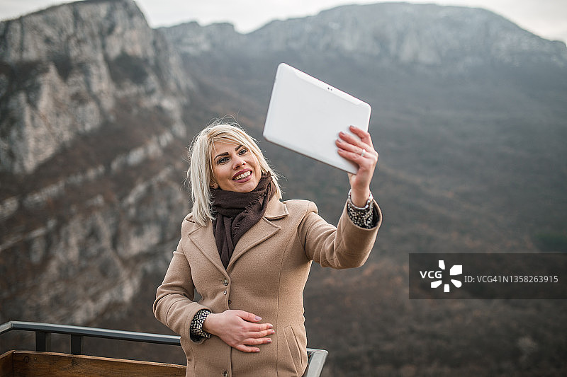 女人通过视频电话向朋友展示壮丽的景色图片素材